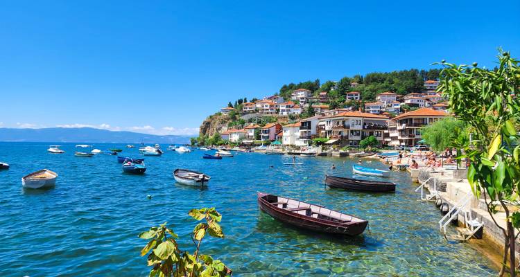 Une ville côtière avec des bateaux le long du rivage et des maisons colorées.
