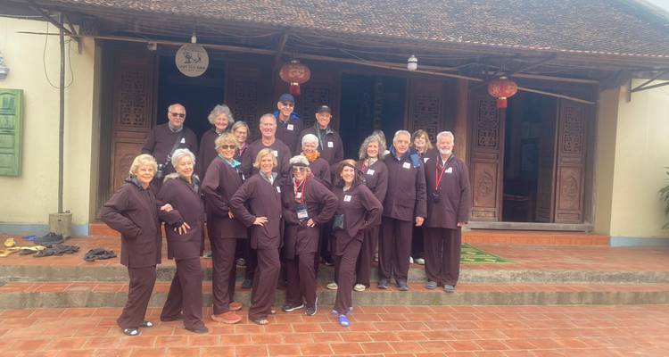 Eine Gruppe von Touristen, die vor einem traditionellen Gebäude posiert.