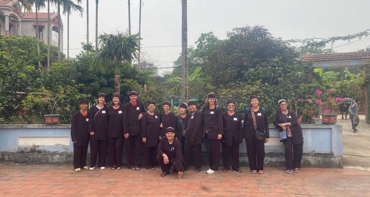 Eine Gruppe von Menschen in traditioneller Kleidung, die in einem Innenhof stehen.