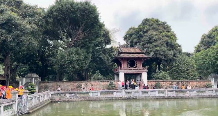 Tempel met een vijver en bezoekers die de architectuur bewonderen.