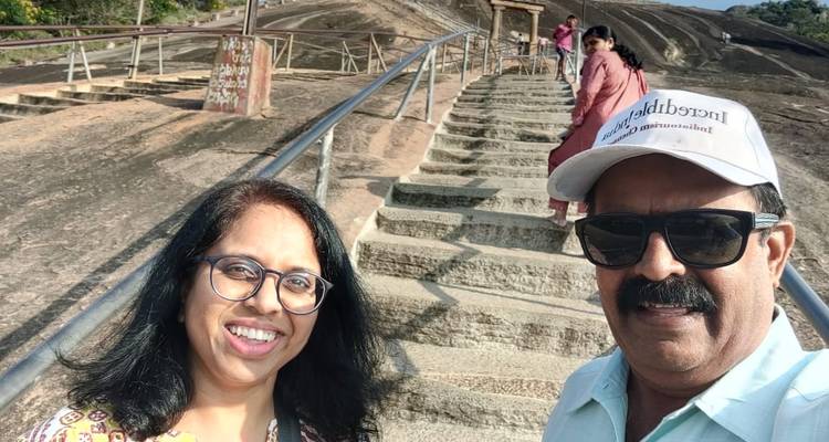 Personas tomándose una selfie en escalones de piedra con una vista panorámica.