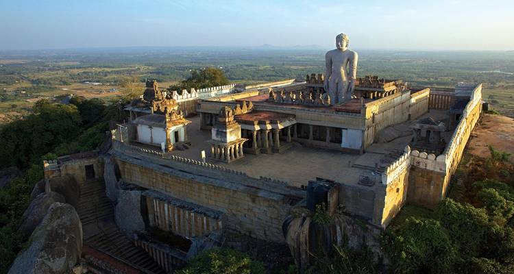 Vista aérea de un complejo de templos antiguos con una estatua grande.