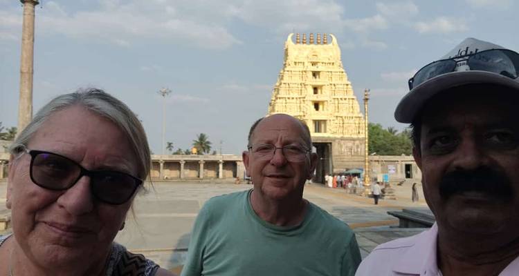 Turistas posando frente a un templo con un gran gopuram.