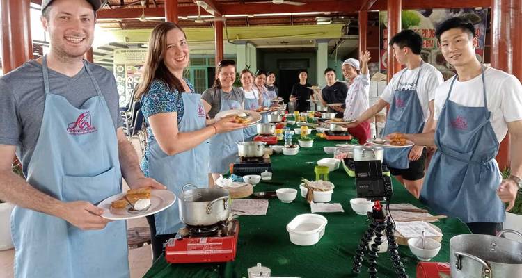 Group of people participating in a cooking class outdoors.