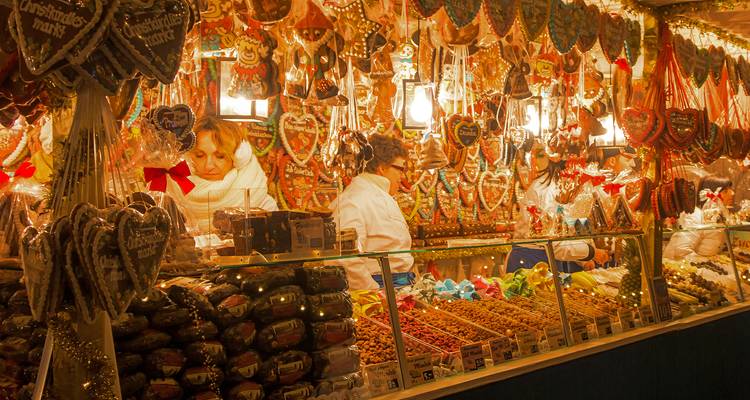 Close-up of gingerbread and sweets stall at a Christmas market with warmly lit decorations.