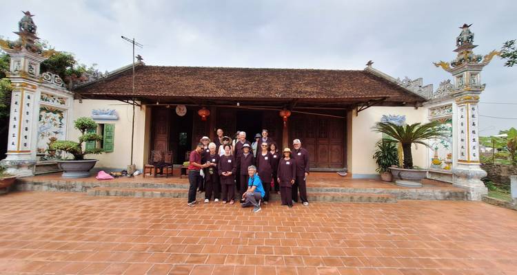 Eine Gruppe von Menschen posiert vor einem traditionellen Gebäude.