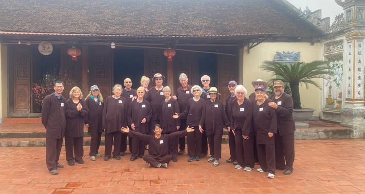 Eine Gruppe von Menschen posiert vor einem traditionellen Gebäude.