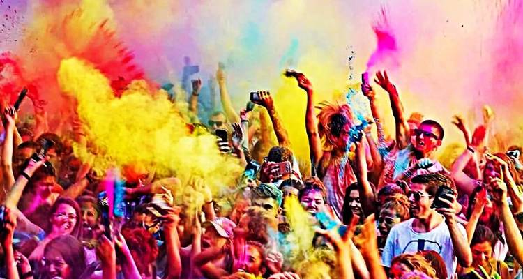 Menigte mensen die feest viert met levendig gekleurd poeder.