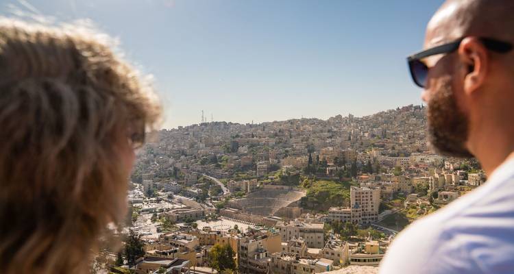 Deux visiteurs admirent le vaste paysage urbain sur la colline baigné dans la lumière du soleil brillant
