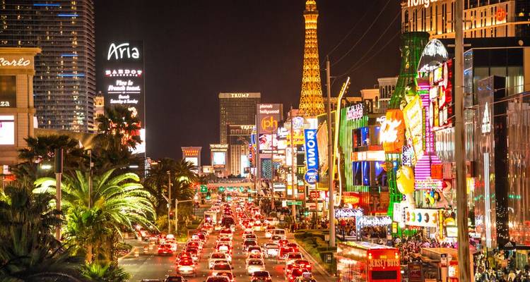 A vibrant and bustling city street at night with illuminated signs.