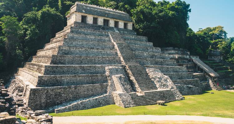 Impresionante templo piramidal escalonado de piedra de Palenque rodeado por la densa vegetación verde de la selva tropical.