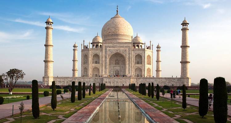 Das ikonische Taj Mahal aus weißem Marmor spiegelt sich in seinem langen Becken unter sanftem Abendlicht
