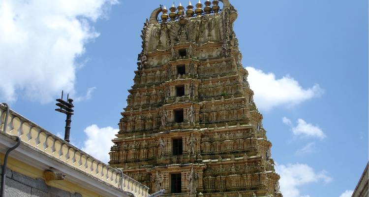 Tall intricately carved temple tower rising toward a bright sky.