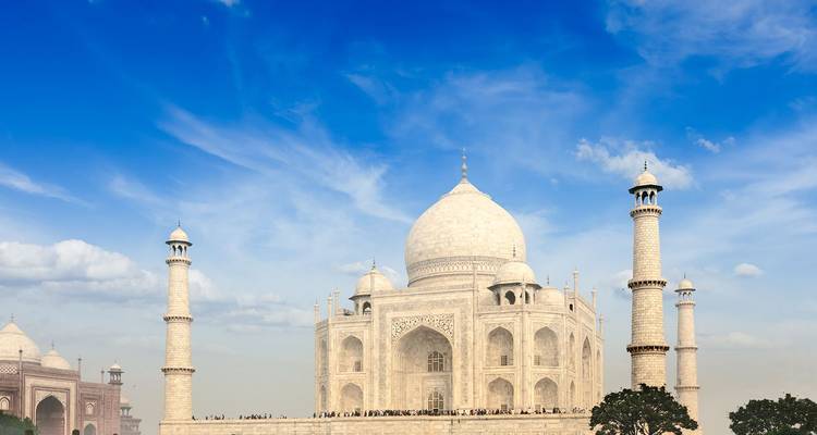 The Taj Mahal stands in pristine white marble beneath a vivid blue sky.