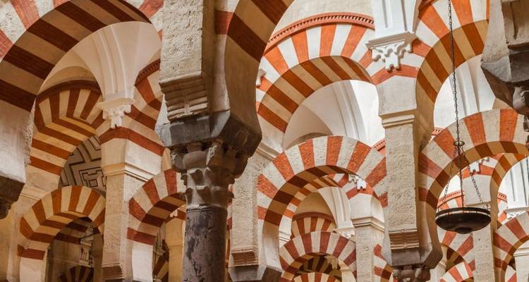 Interieur van een historisch gebouw met kenmerkende rood-witte bogen.