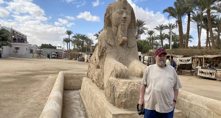 Man poseert naast de Grote Sfinx van Memphis.