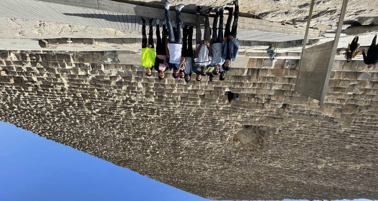 Groep mensen die poseren voor een piramide.