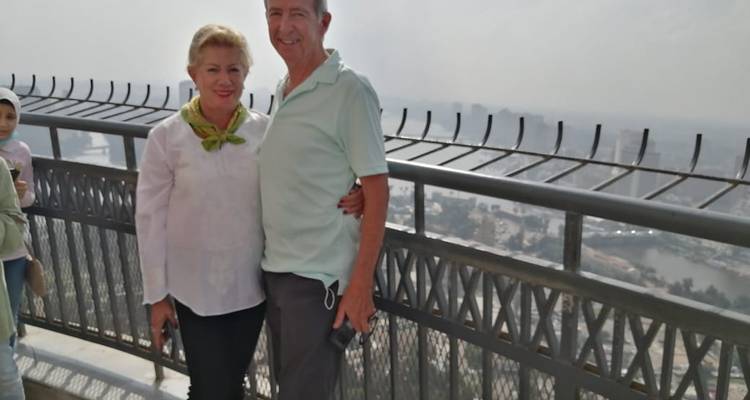 Stel poseert op een hoog balkon met uitzicht op het stadslandschap.
