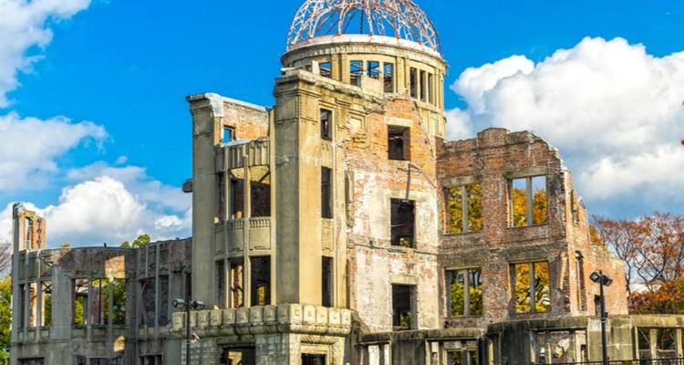 De skelettische Atomic Bomb Dome staat onder een levendig blauwe lucht, een strakke herinnering aan de geschiedenis.