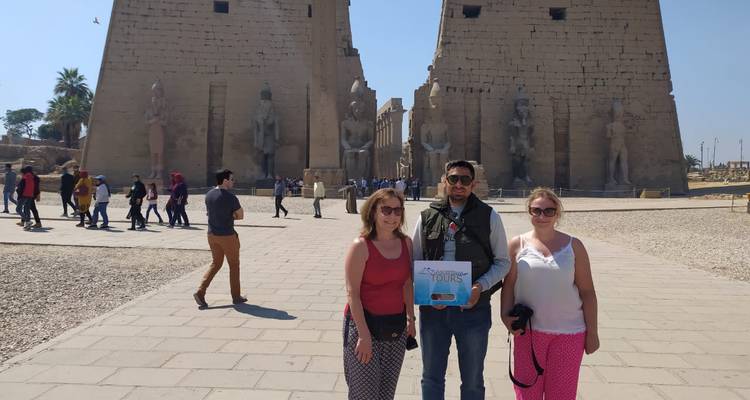 Drie mensen voor een oude Egyptische tempel.