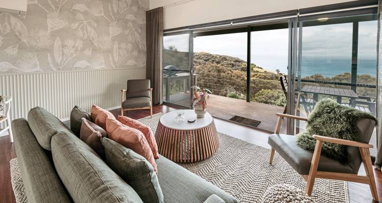 Living area with a view of coastal landscape through large windows.