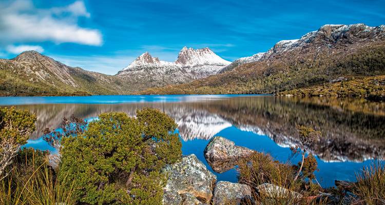 Stunning view of mountains reflecting in a lake with clear skies.