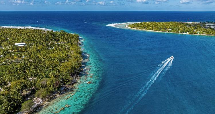 Aerial view of coral atolls and clear ocean waters.