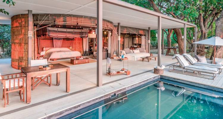 Suite d'hôtel extérieure près d'une piscine avec une décoration élégante.