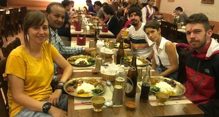 Een groep die geniet van een traditionele maaltijd in een restaurantomgeving.