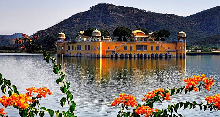 Schilderachtig uitzicht van een paleis dat gedeeltelijk ondergedompeld is in een meer omgeven door bergen.