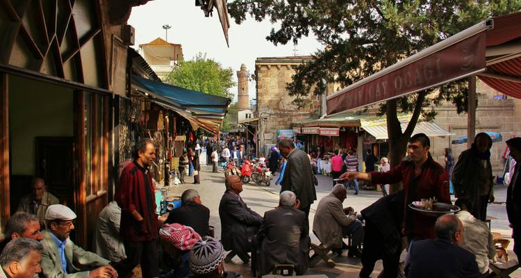 Escena animada de mercado con gente y tiendas.