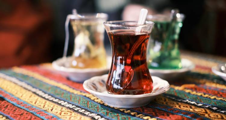 Tres vasos de té turco sobre un paño tejido.