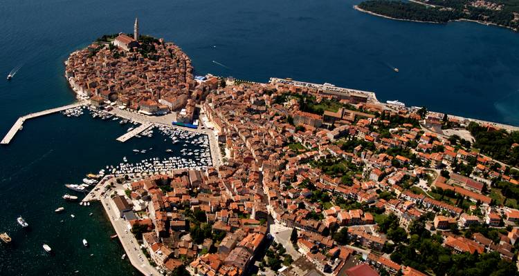 Vista aérea del pueblo peninsular de Rovinj con sus tejados naranjas compactos y puerto deportivo.