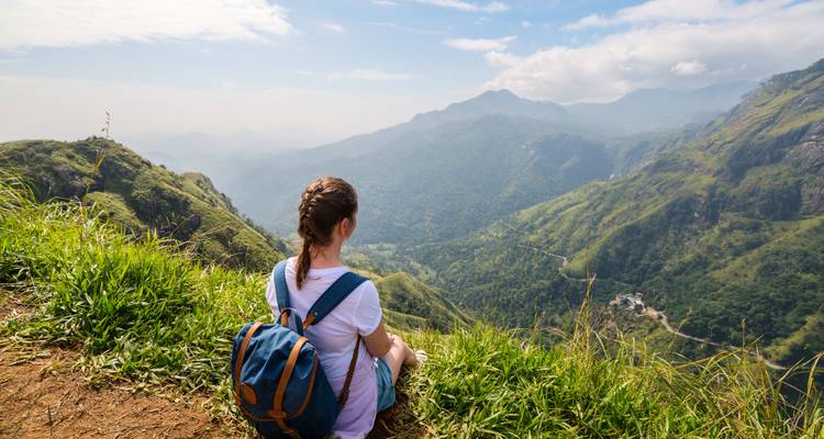 Wandelaar zittend met een schilderachtig bergzicht.