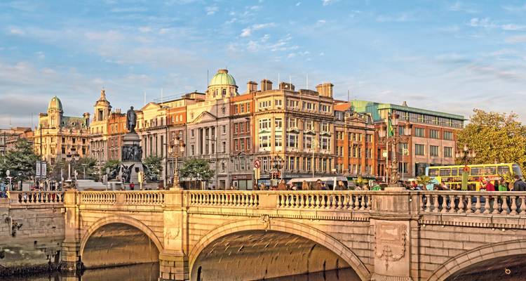 Paysage urbain avec un pont sur une rivière et des bâtiments historiques.
