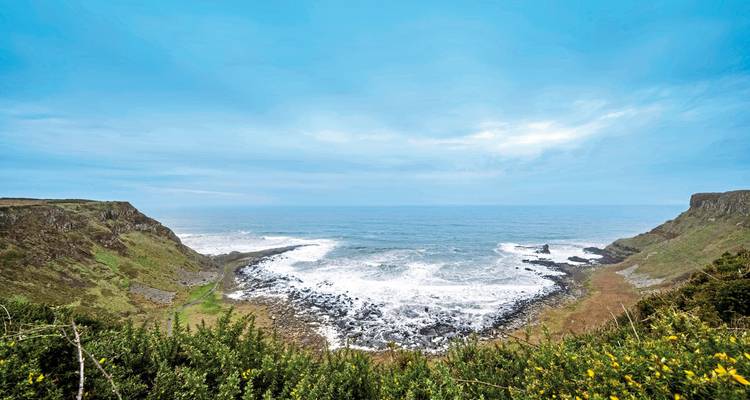 Côte rocheuse avec des vagues s'écrasant contre le rivage.