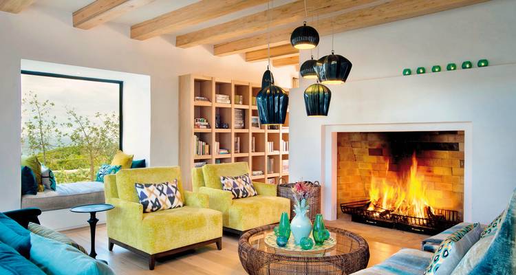 Gemütliches Wohnzimmer mit einem Kamin und farbenfroher Dekoration.