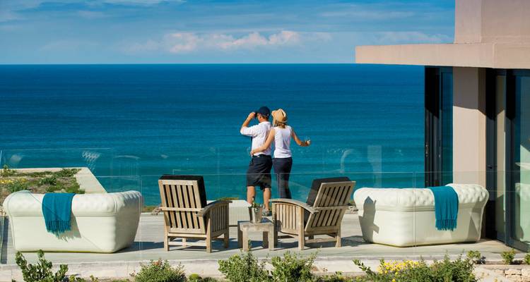 Paar genießt den Blick über das Meer von einer Terrasse.