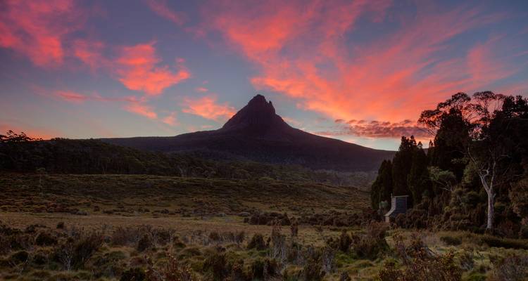 Silhouette de montagnes contre un ciel coloré de lever de soleil.
