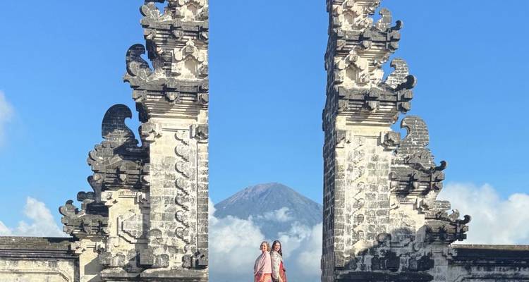 Tourists posing at the Gate of Heaven with Mount Agung in the background.
