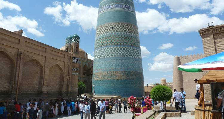 Ein Platz im Freien voller Touristen, mit einem großartigen Turm im Blick.