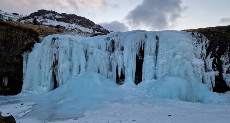 Frozen waterfall with ice formations.