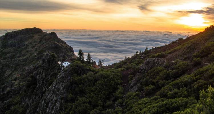 Mountain peak with clouds and sunset colors.