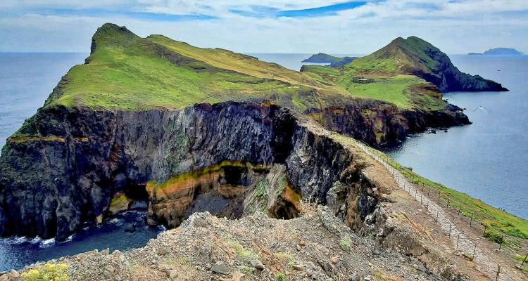 Island landscape with rugged cliffs and verdant hills.