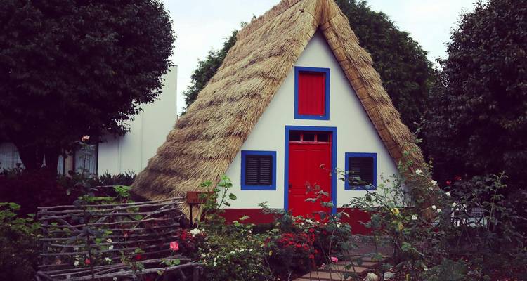 Traditional triangular house with a thatched roof