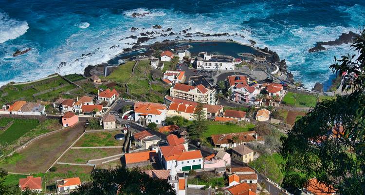 Aerial view of a coastal village with natural swimming pools.
