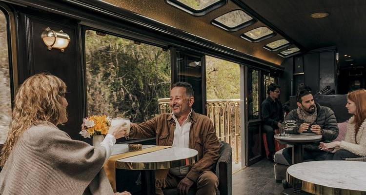 Menschen, die eine Mahlzeit in einem luxuriösen Zuginterieur genießen.