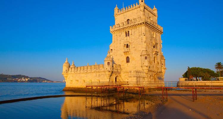 Torre de Belém contra una puesta de sol dorada.