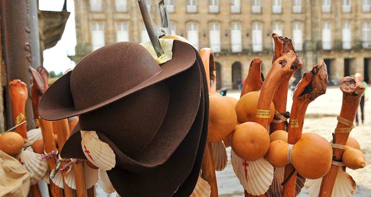 Chapeaux traditionnels et cannes de marche exposés sur un marché.