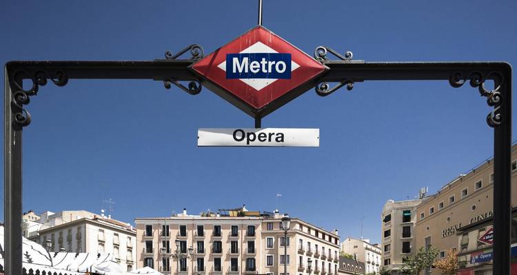 Panneau de métro avec l'architecture d'un bâtiment historique en arrière-plan.